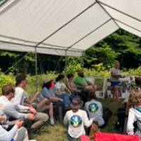 Beaver Island Participants gather under sun tent for lecture